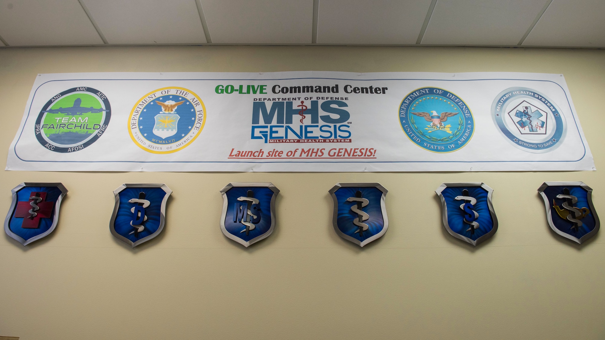 A banner marking Fairchild's 92nd Medical Group as an initial testing site for Military Health System Genesis hangs on the wall during the celebration of the second year anniversary MHS Genesis' implementation at Fairchild Air Force Base, Washington, Feb. 8, 2019. Fairchild’s 92nd MDG was selected as the first Department of Defense medical clinic to launch this $11 billion electronic health record system and has successfully used the program since Feb. 7, 2017. (U.S. Air Force photo/Airman 1st Class Lawrence Sena)
