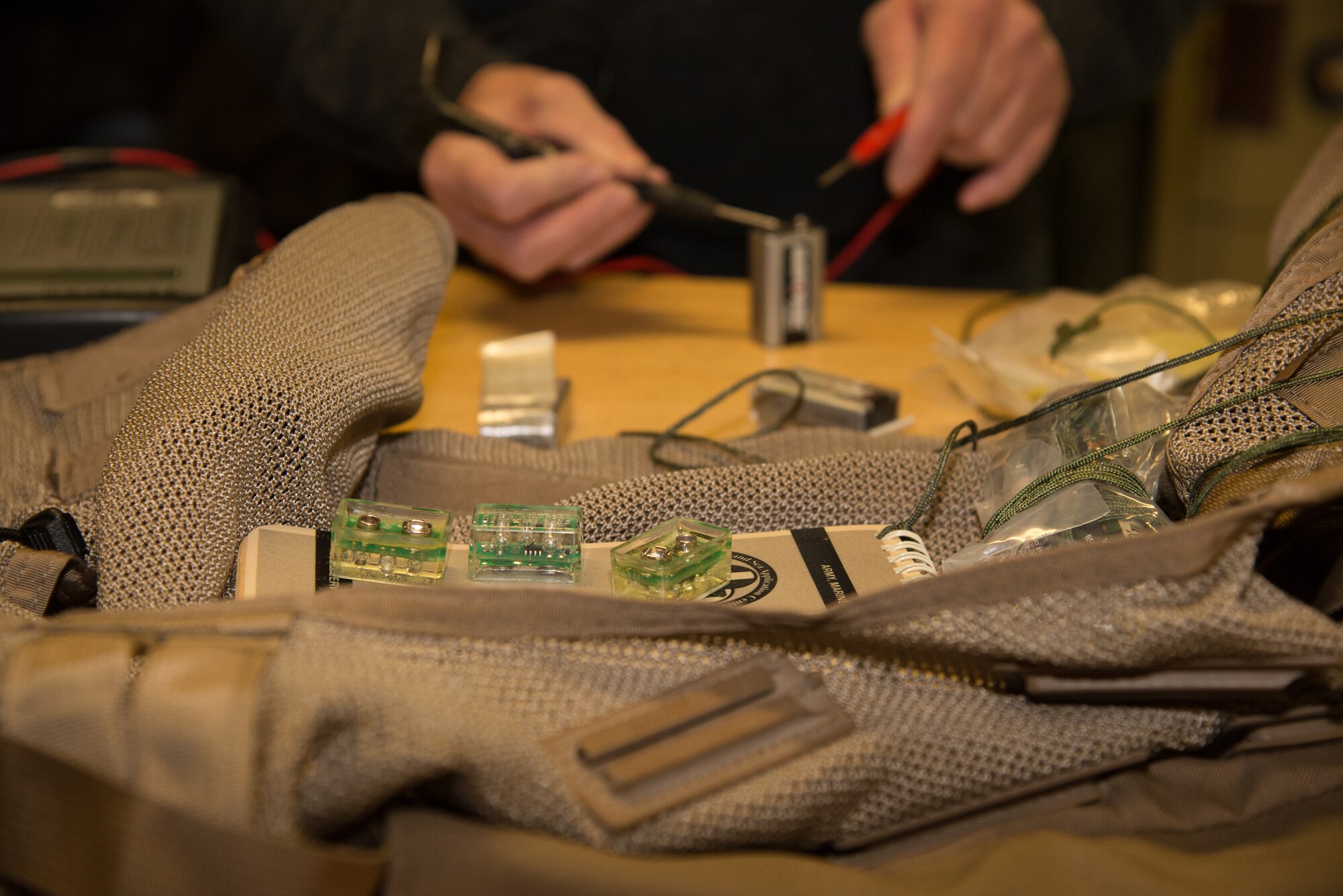 Tech. Sgt. Kelly Baker, a 302nd Maintenance Squadron aircrew flight equipment specialist, tests a battery used to power a small infrared light inside a survival vest designed for aircrew members Feb. 1, 2019, at Peterson Air Force Base, Colorado.