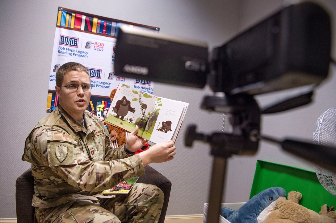 U.S. Air Force Capt. Nathan Badger, 34th Intelligence Squadron flight commander, records himself reading a book as part of United Service Organizations (USO) Qatar’s reading program Feb. 8, 2019, at Al Udeid Air Base, Qatar. The USO reading program allows service members to record themselves reading books to send back to their children. Program participants can write messages in the books and send them to their children along with the video recording. (U.S. Air Force photo by Tech. Sgt. Christopher Hubenthal)