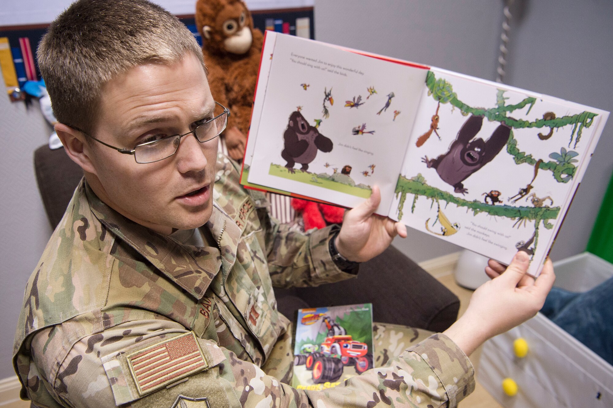U.S. Air Force Capt. Nathan Badger, 34th Intelligence Squadron flight commander, records himself reading a book as part of United Service Organizations (USO) Qatar’s reading program Feb. 8, 2019, at Al Udeid Air Base, Qatar. The USO reading program allows service members to record themselves reading books to send back to their children. Program participants can write messages in the books and send them to their children along with the video recording. (U.S. Air Force photo by Tech. Sgt. Christopher Hubenthal)