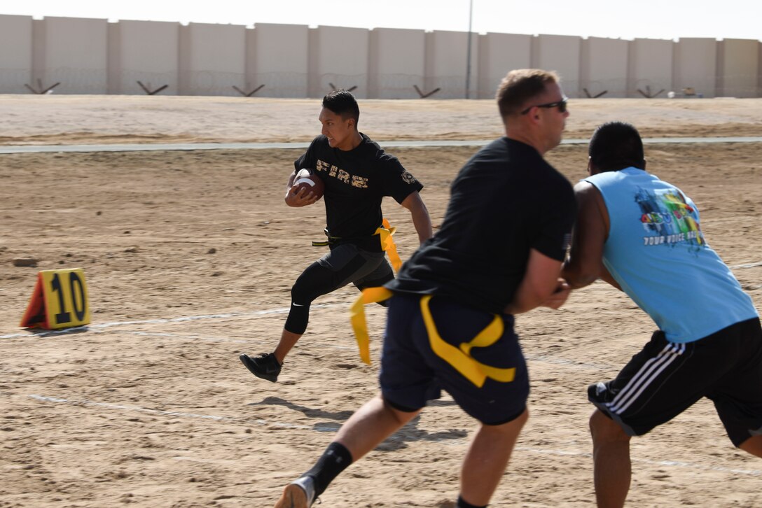 Members assigned to Al Dhafra Air Base, United Arab Emirates, participate in an intramural football tournament game, Nov. 11, 2018. The 380th Expeditionary Force Support Squadron Fitness Center Staff hosts intramural sporting including softball, football and basketball, for ADAB personnel to remain fit to fight while having fun. (U.S. Air Force photo by Tech. Sgt. Darnell T. Cannady)