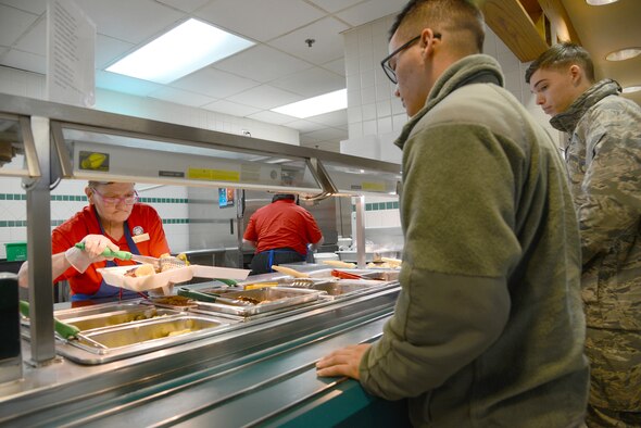 Lonita Ewing serves a heaping portion of steamed brussels sprouts to Airman 1st Class Devin Watrous, with the 552nd Operations Support Squadron, at the Vanwey Dining Facility Feb. 7.