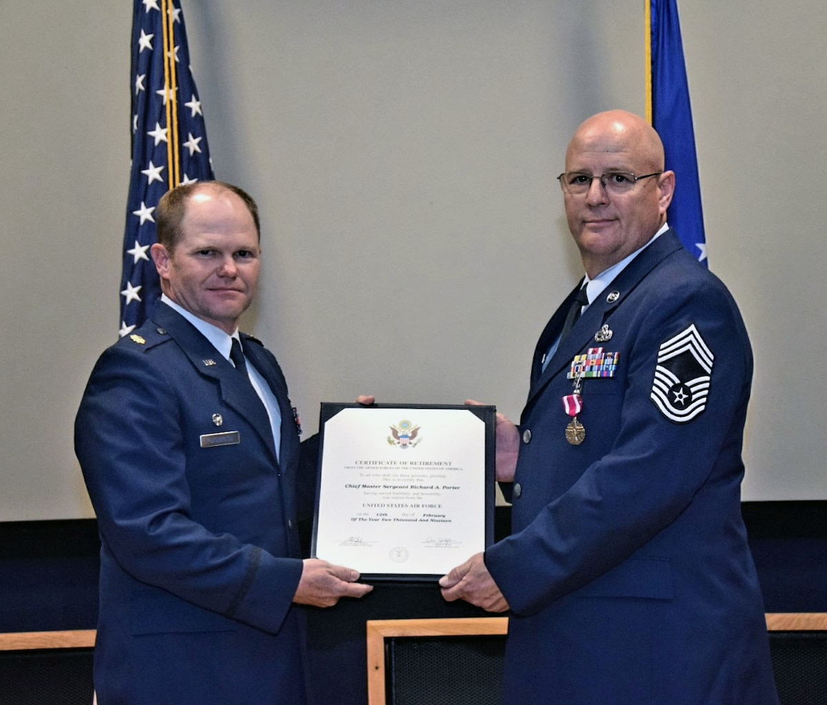 Maj. A. Spence Pennington, 433rd Maintenance Squadron commander, presents a certificate of retirement to Chief Master Sgt. Richard A. Porter, 433rd MXS superintendent, at a ceremony in the 433rd Airlift Wing Auditorium at Joint Base San Antonio-Lackland, Texas Feb. 9, 2019.