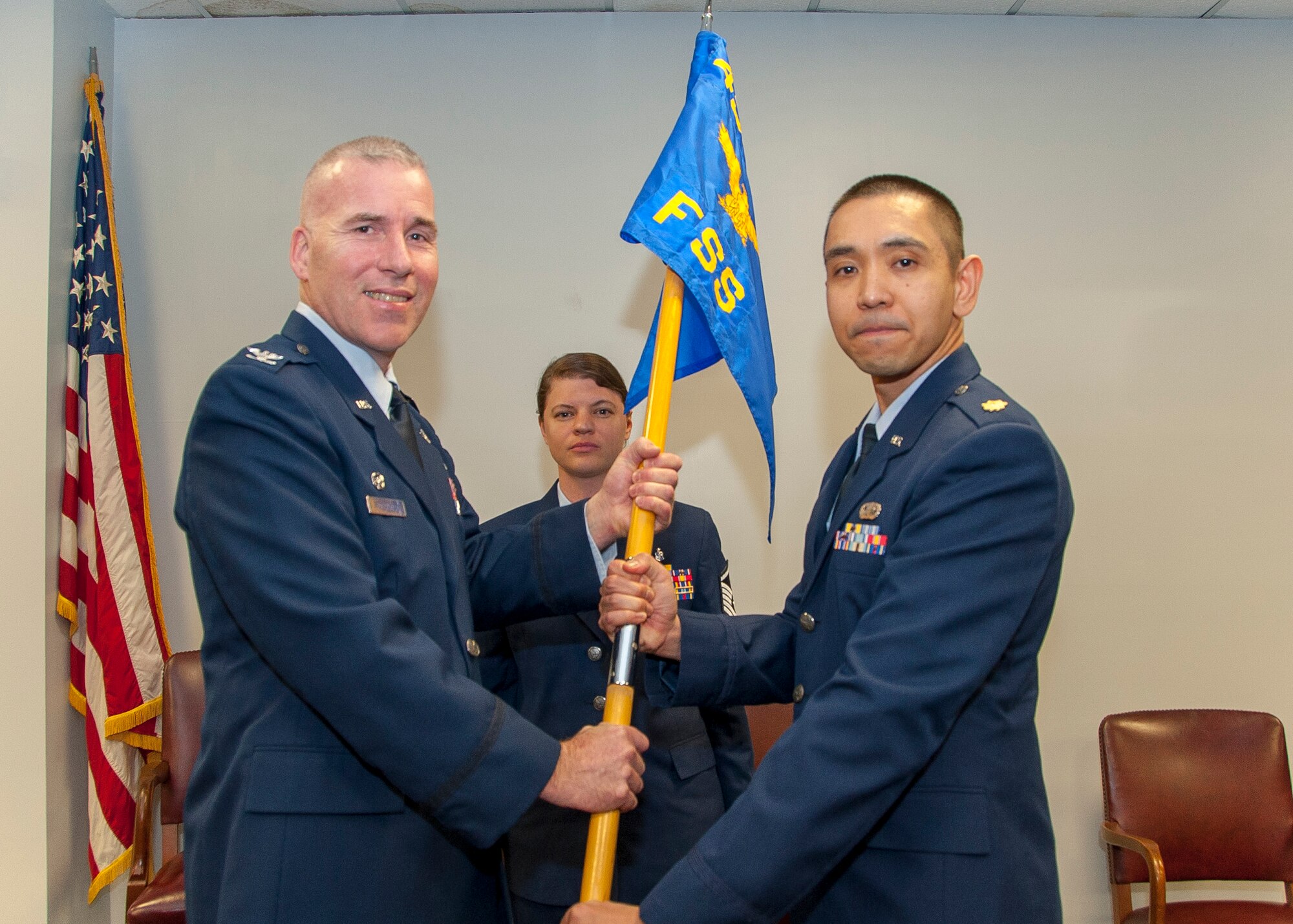 Col. Roger R. Stoeckmann, commander of the 459th Mission Support Group, passes the guidon to Maj. Billy J. Ancheta, commander of the 459th Force Support Squadron, during an assumption of command ceremony at Joint Base Andrews, Maryland, Feb. 9, 2019. Ancheta’s previous assignment was with the Force Visibility Branch for the Generation Center where he served as the chief. (Photo by U.S. Air Force Senior Airman Andreaa Phillips)