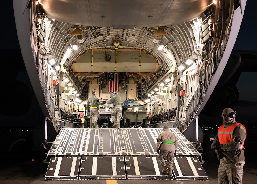 Airmen from the 104th Logistics Readiness Squadron work with the crew from a C-17 Globemaster III from the 105th Airlift Wing in Stewart, New York to unload equipment off the aircraft Feb. 8, 2019, at Barnes Air National Guard Base, Massachusetts. The C-17 supported the 104th Fighter Wing by bringing 104 FW Airmen back from a temporary duty assignment at Patrick Air Force Base in Florida.  (U.S. Air National Guard photos by Airman Sara Kolinski)