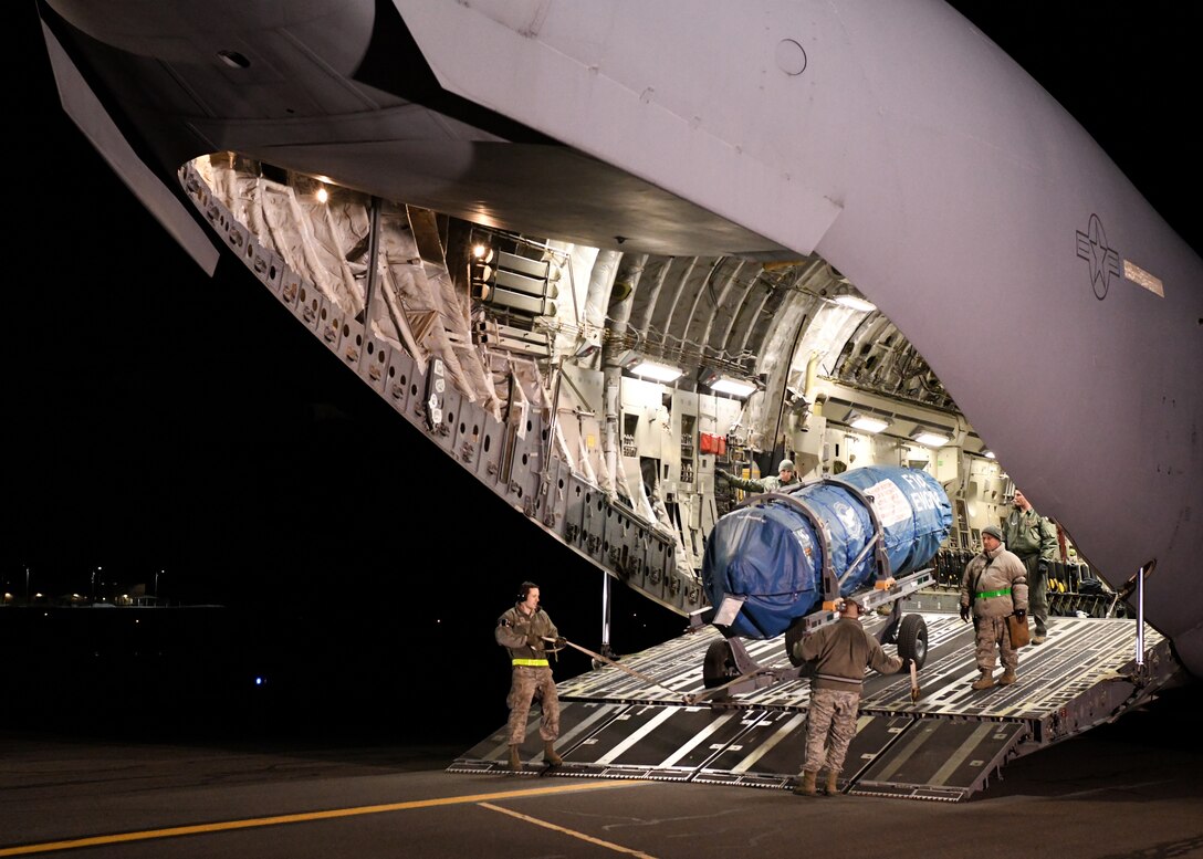 Airmen from the 104th Logistics Readiness Squadron work with the crew from a C-17 Globemaster III from the 105th Airlift Wing in Stewart, New York to unload equipment off the aircraft Feb. 8, 2019, at Barnes Air National Guard Base, Massachusetts. The C-17 supported the 104th Fighter Wing by bringing Airmen and equipment such as engines, back from a temporary duty assignment at Patrick Air Force Base, Florida.  (U.S. Air National Guard photos by Airman Sara Kolinski)