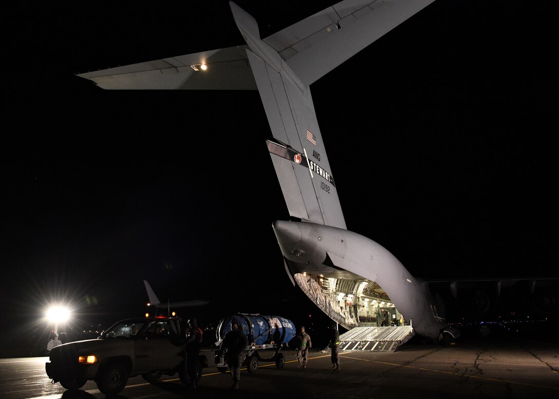 Airmen from the 104th Logistics Readiness Squadron help unload an engine off a C-17 Globemaster III from the 105th Airlift Wing in Stewart, New York to unload equipment off the aircraft Feb. 8, 2019, at Barnes Air National Guard Base, Massachusetts. Airmen from the 104th Fighter Wing who were on a temporary duty assignment at Patrick Air Force Base in Florida returned home on the C-17.  (U.S. Air National Guard photos by Airman Sara Kolinski)