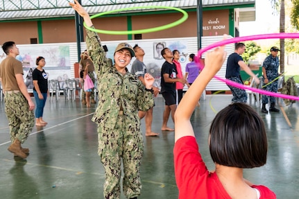 190209-N-DX072-1072 CHONBURI, Thailand (Feb. 9, 2019) – Lt. j.g. Jasmin Nicasio, from San Diego, hula hoops with a child during a community service project at the Child Protection and Development Center in Chonburi, Thailand. The amphibious transport dock ship USS Green Bay (LPD 20), part of the Wasp Amphibious Ready Group, with embarked 31st Marine Expeditionary Unit (MEU), is in Thailand to participate in Exercise Cobra Gold 2019. Cobra Gold is a multinational exercise co-sponsored by Thailand and the United States that is designed to advance regional security and effective response to crisis contingencies through a robust multinational force to address common goals and security commitments in the Indo-Pacific region.