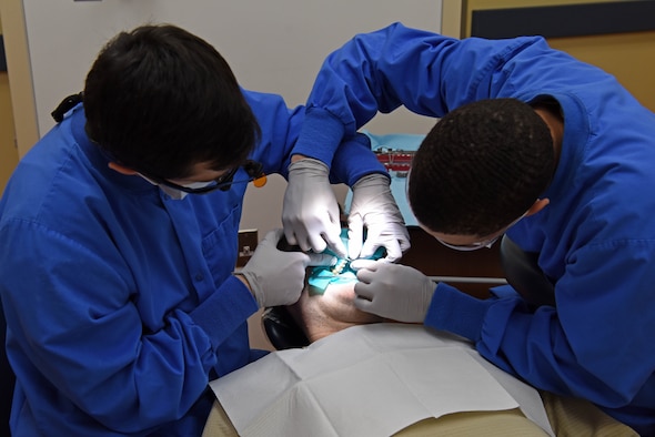 U.S. Air Force Capt. Michael Santora, 8th Medical Operations Squadron dentist, and Senior Airman Keyshawn Everett, 8th MDOS dental assistant, prepare a patient for a filling at the dental building on Kunsan Air Base, Jan. 20, 2019. The dental clinic offers a variety of services including cleanings, fillings and extractions. (U.S. Air Force photo by Staff Sgt. Joshua Edwards)