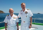 Adm. James G. Foggo III, commander, U.S. Naval Forces Europe-Africa and commander, Allied Joint Force Command Naples, Italy, right, and the Chief of Staff of the Spanish navy Adm. Gen. López Calderón pose for a photo with USS Donald Cook (DDG 75) in the background before a commemoration ceremony honoring the 150-year legacy of Adm. David Farragut in Minorca, Spain, June 16, 2018.