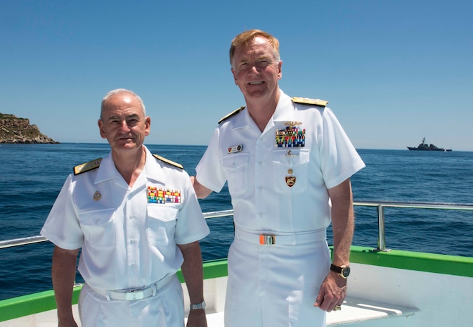 Adm. James G. Foggo III, commander, U.S. Naval Forces Europe-Africa and commander, Allied Joint Force Command Naples, Italy, right, and the Chief of Staff of the Spanish navy Adm. Gen. López Calderón pose for a photo with USS Donald Cook (DDG 75) in the background before a commemoration ceremony honoring the 150-year legacy of Adm. David Farragut in Minorca, Spain, June 16, 2018.