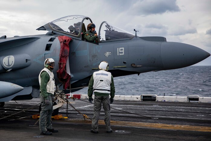 Italian navy sailors perform pre-flight checks on an AV-8B Harrier on the flight deck of the Wasp-class amphibious assault ship USS Kearsarge (LHD 3).