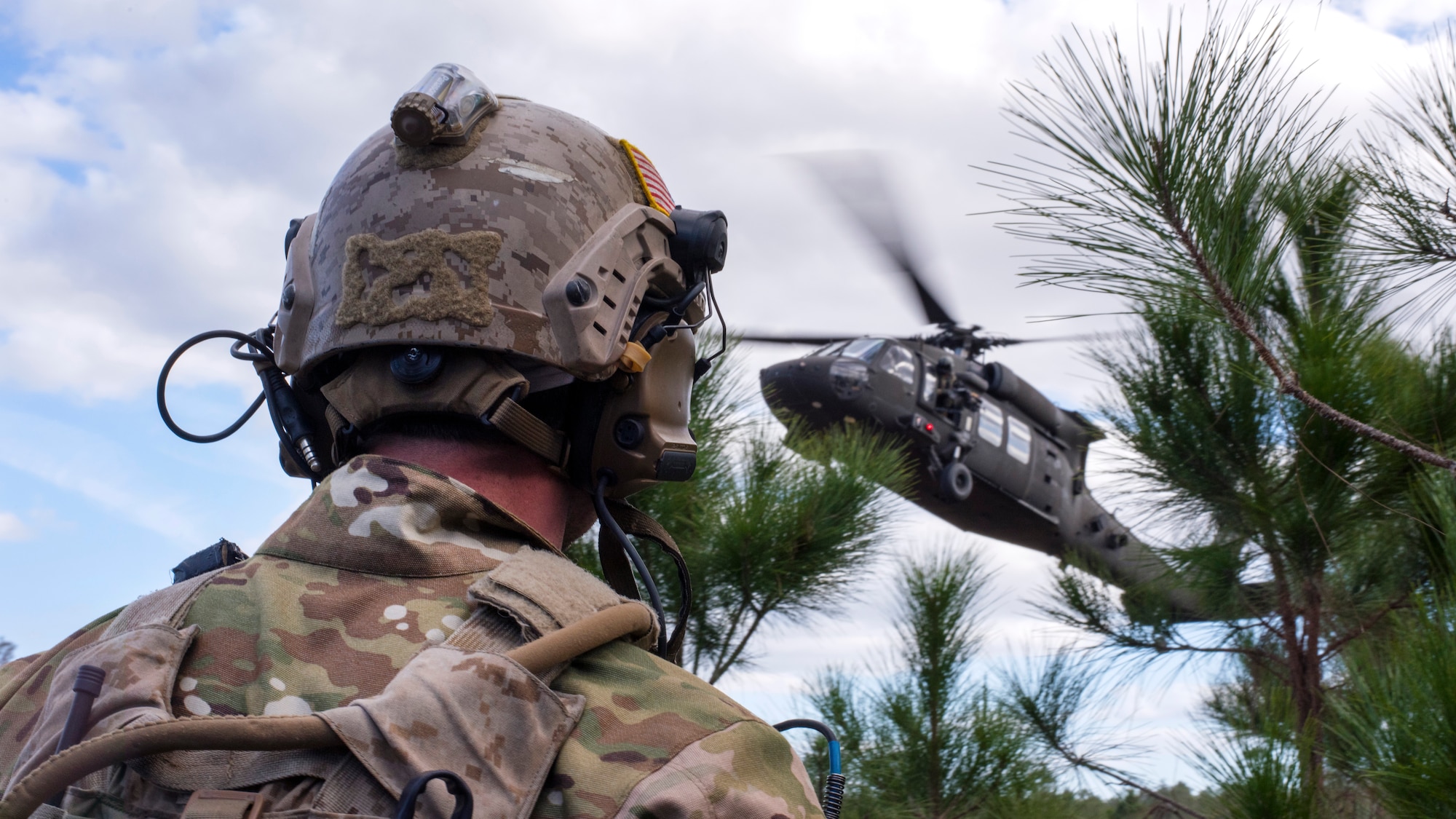 A U.S. Navy Sea, Air and Land (SEAL) team member awaits extraction from a UH-60 Black Hawk helicopter during an Emerald Warrior 2019 search and rescue training exercise, Jan. 22, 2019.