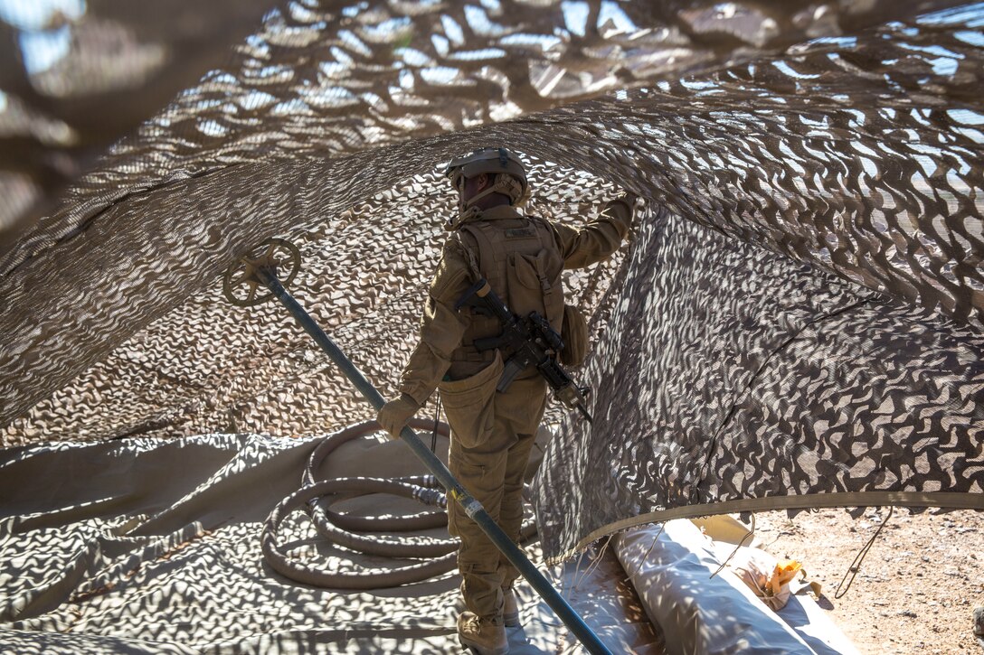 A U.S. Marine assigned to Marine Wing Support Squadron 371 (MWSS-371), helps set up a light-weight camouflage screen system (LCSS) at Forward Armored Refueling Point -  LZ Star, Jan. 22, 2019. During this portion of their training exercise, the bulk fuels specialists practiced working together to put together a camouflaged camp at FARP - LZ Star. MCAS Yuma is a prime location to conduct military training with its variety of different training range; both foreign military units and all branches of the U.S. military that visit the air station utilize the ranges throughout the year. (U.S. Marine Corps photo by Cpl. Isaac D. Martinez)