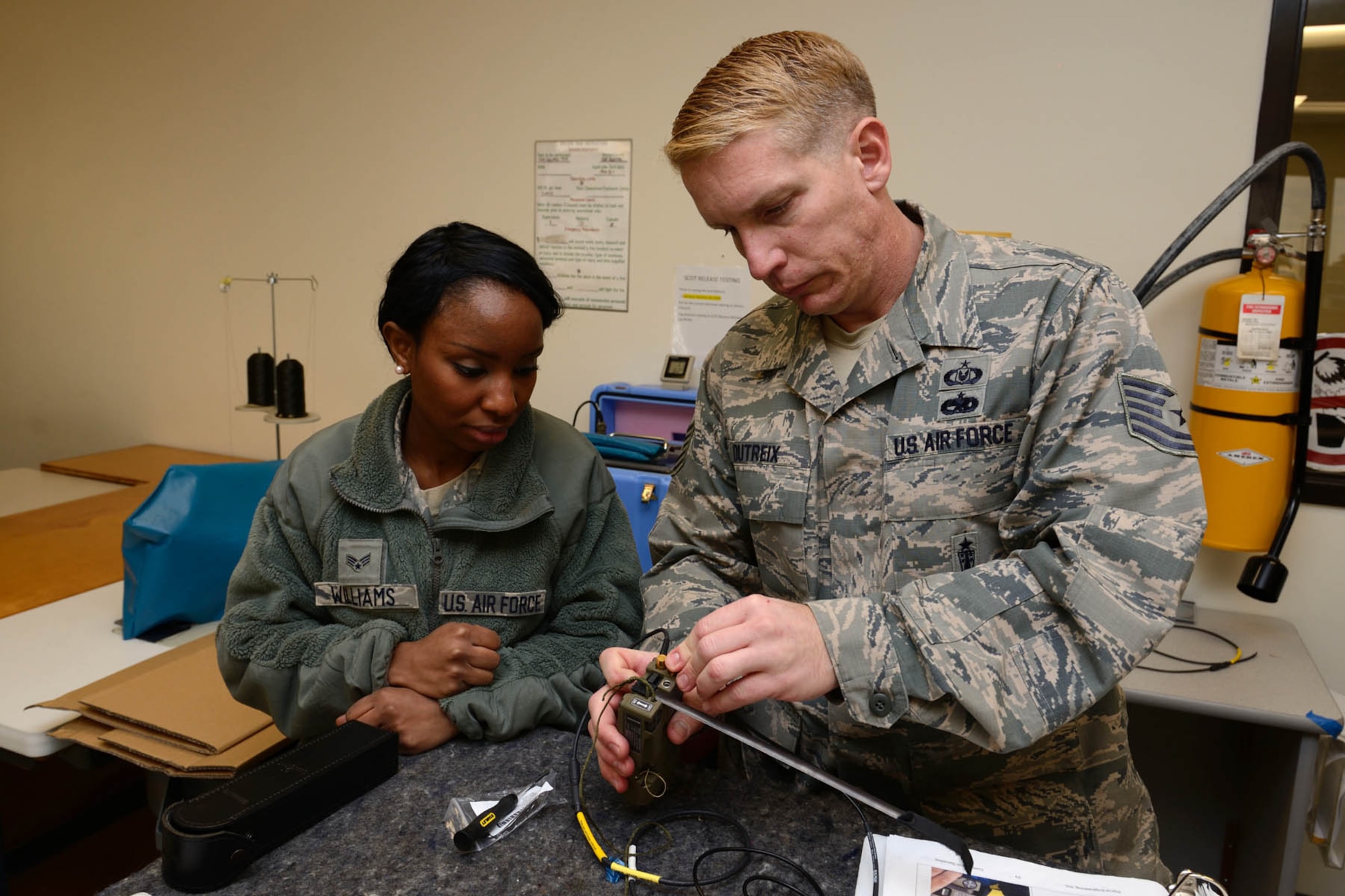 Tech. Sgt. Brandon Dutreix, 403rd Operations Support Squadron aircrew flight equipment craftsman, instructs Senior Airman Tabitha Williams, 403rd OSS aircrew flight equipment journeyman, on how to assemble and inspect an AN/URT-44 personnel locator beacon January 10, 2015. The Air Force Life Cycle Management Center's Agile Combat Support Directorate is currently fielding 12,000 new personnel locator beacons to replace the URT-44(U.S. Air Force photo/Tech. Sgt. Ryan Labadens)