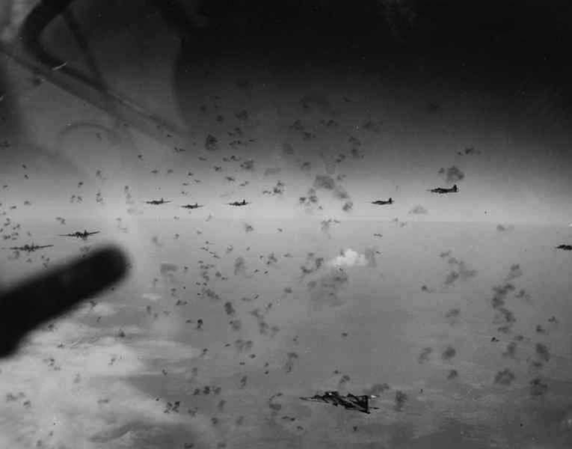 B-17 formation under attack during a bombing raid on an industrial target in Germany, probably sometime in 1943. By fall 1943, German antiaircraft defenses—fighters, ground-based anti-aircraft artillery batteries and specially designed flak towers around key industrial centers—had become quite formidable. The black smoke dots came from exploding AAA shells, fitted with proximity fuses. (U.S. Air Force photo)