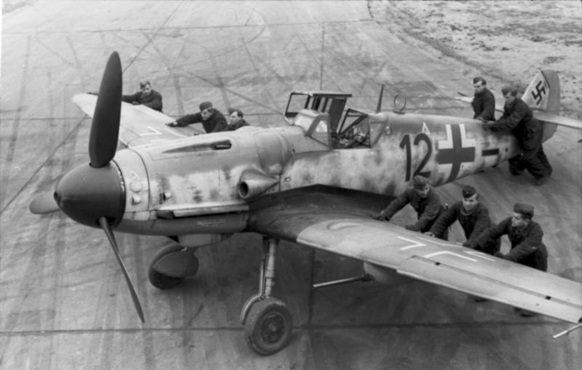 Luftwaffe ground crew positioning a Messerschmitt Bf 109G-6 equipped with an underwing gondola cannon kit, assigned to a Luftwaffe squadron in France, late 1943. The cannon was especially effective in attacking American strategic bombers. This aircraft was one of several types of German fighters that engaged B-17 bombers and P-51 fighters during Operation Argument. (Archive photo)