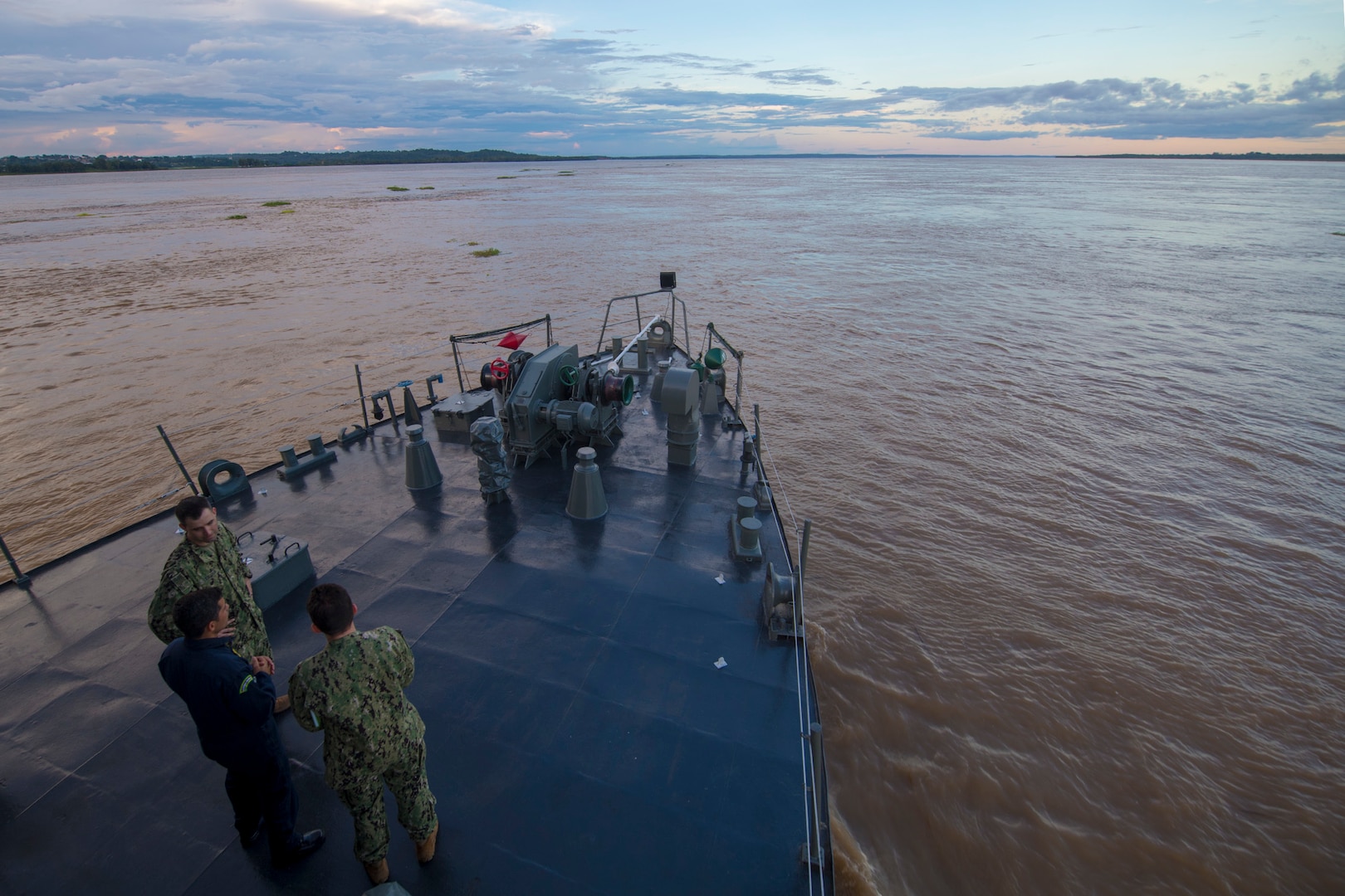 Lt. John Sullivan, Brazilian Navy Capt. Hilcelio Freitas, and Lt. Cmdr. Robert Lennon converse as the Oswaldo Cruz-class hospital ship NAsH Carlos Chagas (U19) enters the Amazon River to commence a month-long humanitarian mission, Feb. 4.