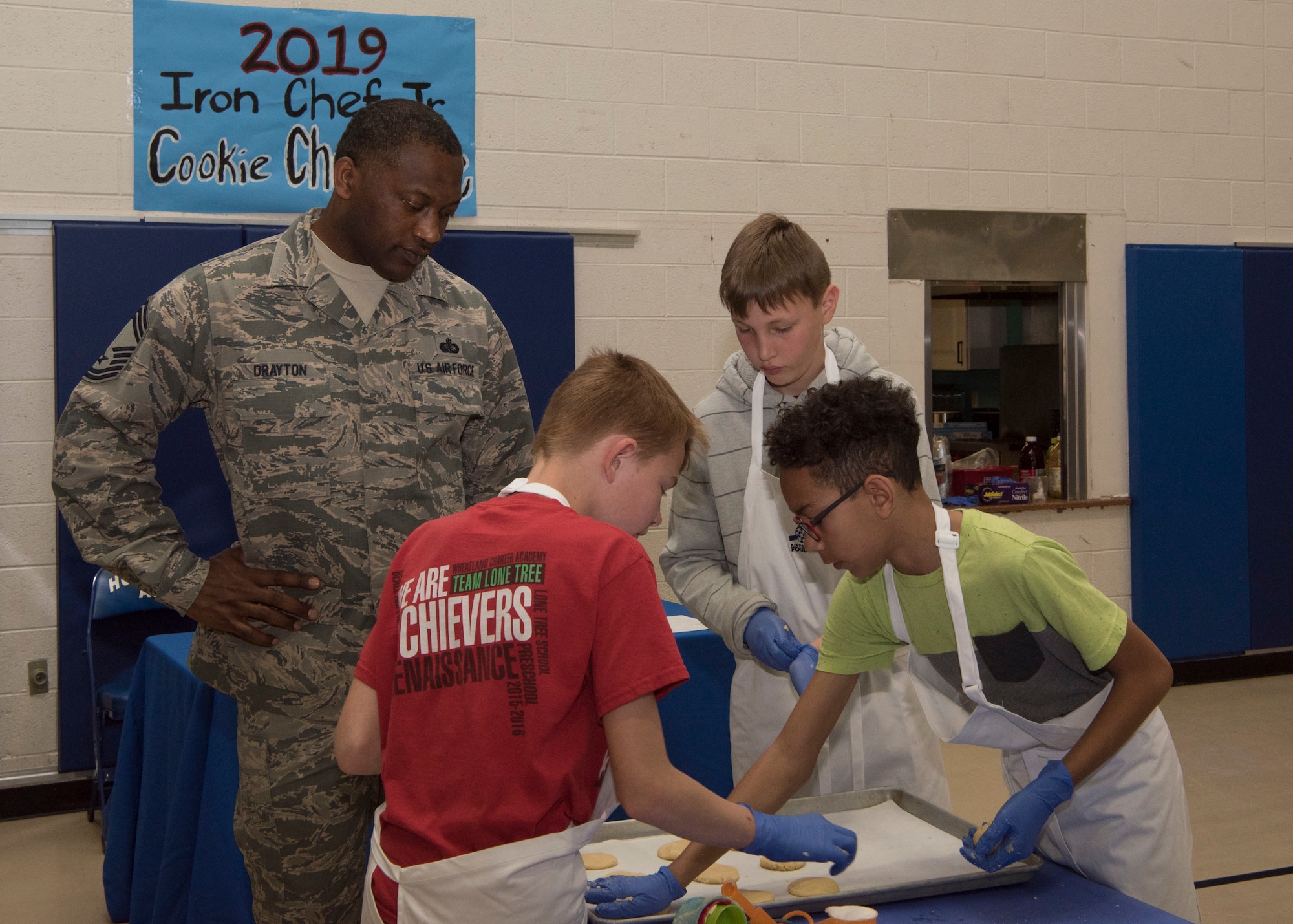 Chief Master Sgt. Bobby Drayton, 49th Force Support Squadron superintendent, watches team Papyrus’ Cookie Corner place sugar cookies on a baking sheet, Jan. 30, 2019, on Holloman Air Force Base, N.M. Seventeen members of the Youth and Teen Center signed up for a cookie baking competition and the competition lasted two and a half hours. (U.S. Air Force photo by Airman Autumn Vogt)