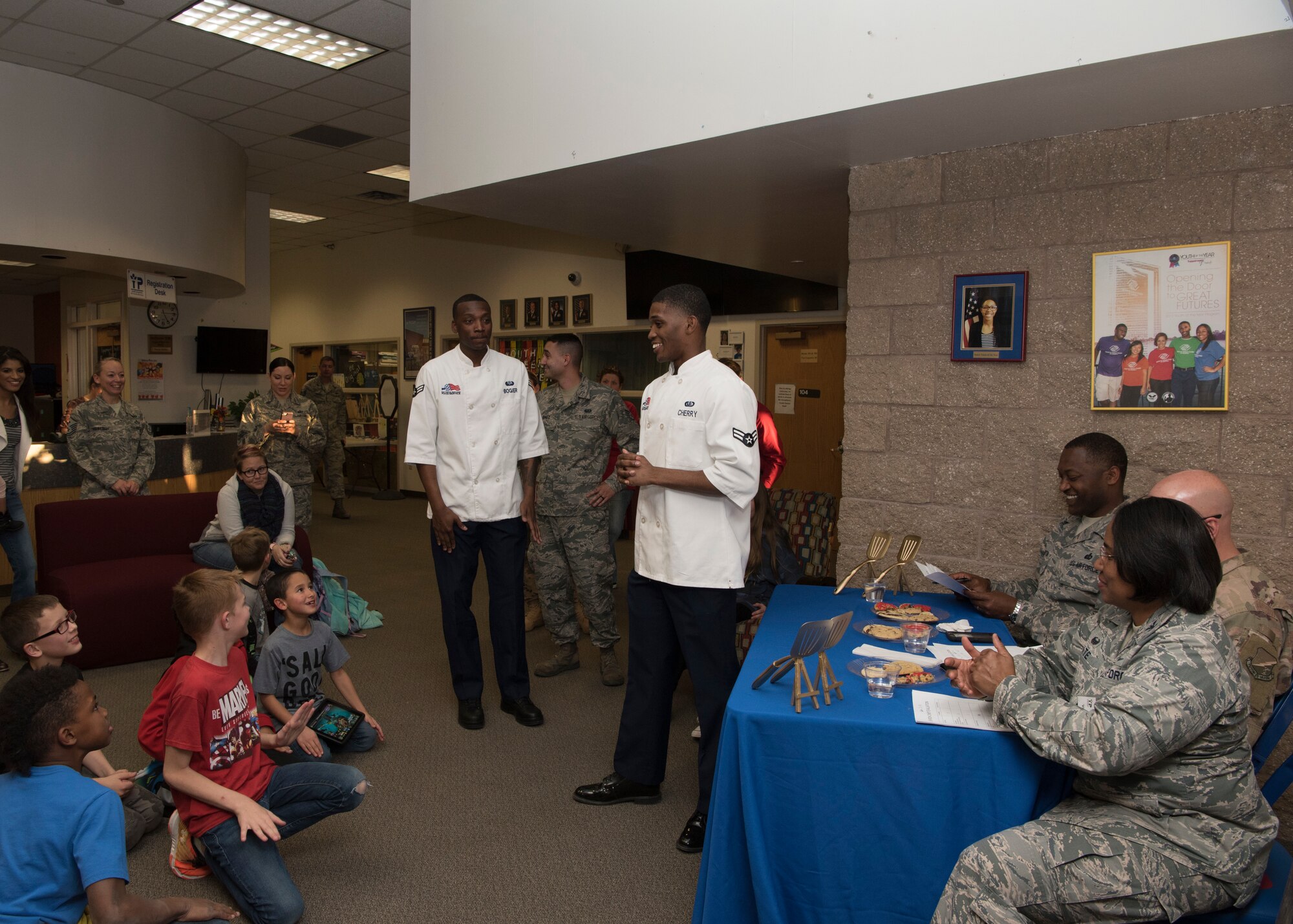 Youth gather as Airman 1st Class Malik Cherry, 49th Force Support Squadron food service specialist (middle), announces who won the baking competition, Jan. 30, 2019, on Holloman Air Force Base, N.M. Out of the five teams from the Youth and Teen Center competing in cookie baking, Papyrus’s Cookie Corner, was announced as the winner and received golden spatulas. (U.S. Air Force photo by Airman Autumn Vogt)
