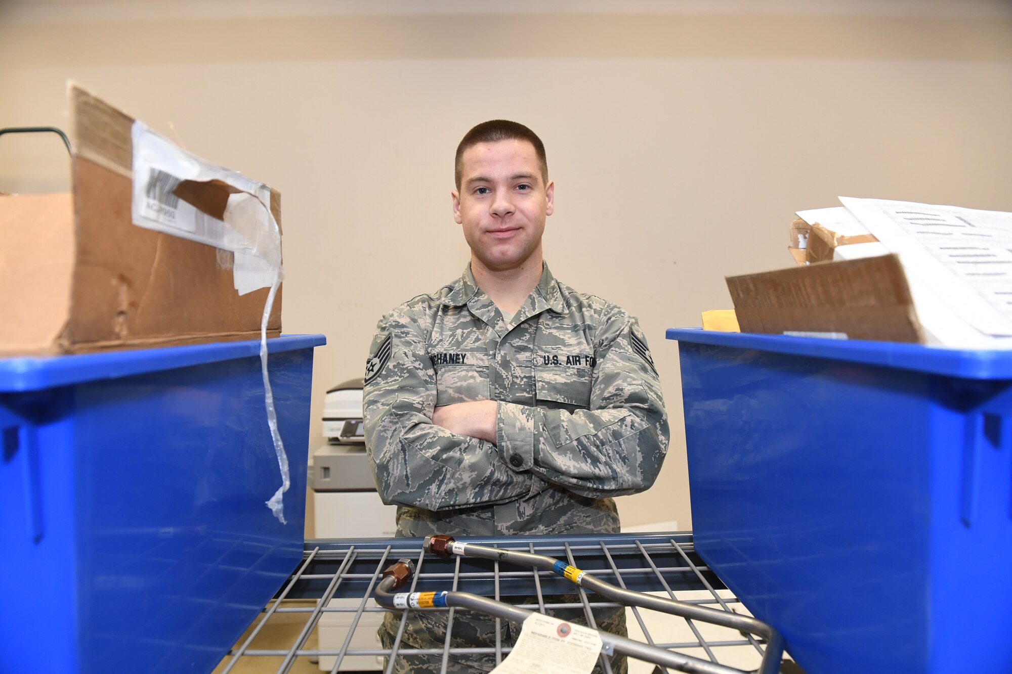 An Airman poses for a photo with his arms crossed