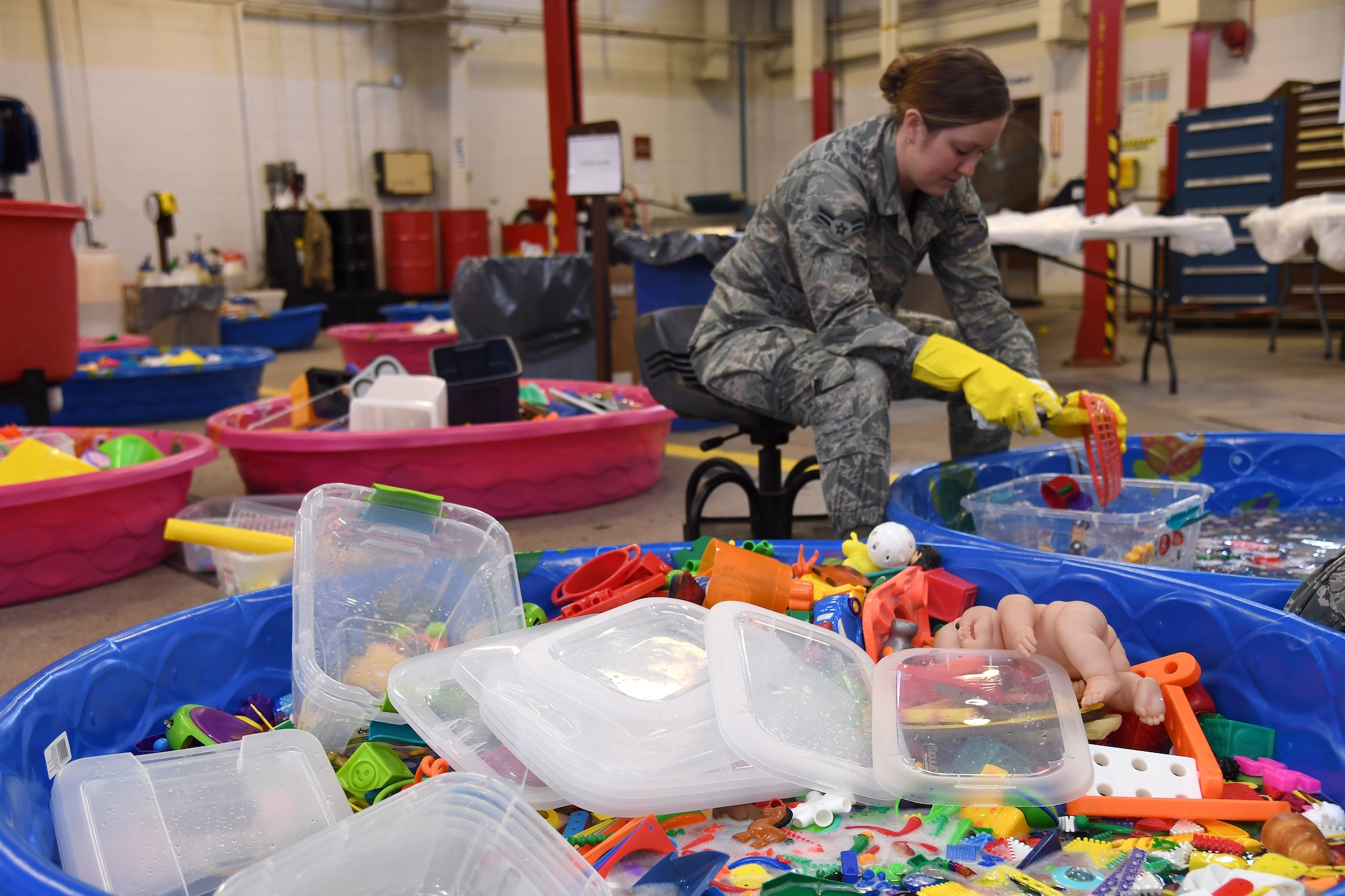 Airman 1st Class Gianna Leupp, 319th Logistics Readiness Squadron customer service representative, scrubs toys from the base Child Development Center and Youth Programs in a bath of soapy water January 18, 2019, on Grand Forks Air Force Base, North Dakota. After several base members contracted a highly-contagious gastrointestinal virus, base public health advised all public-access toys were soaked in a bleach solution prior to being scrubbed in soapy water, rinsed in clean water and air-dried in order to be properly sanitized. (U.S. Air Force photo by Senior Airman Elora J. Martinez)