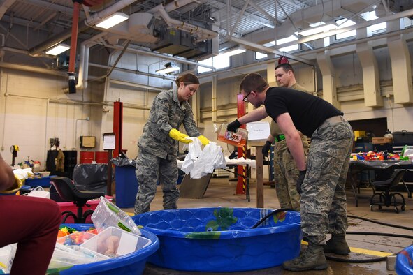 Airmen with the 319th Logistics Readiness Squadron work together to fill a small pool with soapy water to clean thousands of toys January 18, 2019, on Grand Forks Air Force Base, North Dakota. Toys from the Child Development Center and Youth Programs went through a deep-clean over a period of several days: first soaked in a bleach solution, then hand-scrubbed in soapy water and rinsed with clean water before being left to air-dry. The thorough process ensured once sanitized, all frequently-used toys could be returned to base children without risk re-infecting them with a gastrointestinal virus which affected nearly more than 100 personnel and family members in the weeks prior. (U.S. Air Force photo by Senior Airman Elora J. Martinez)