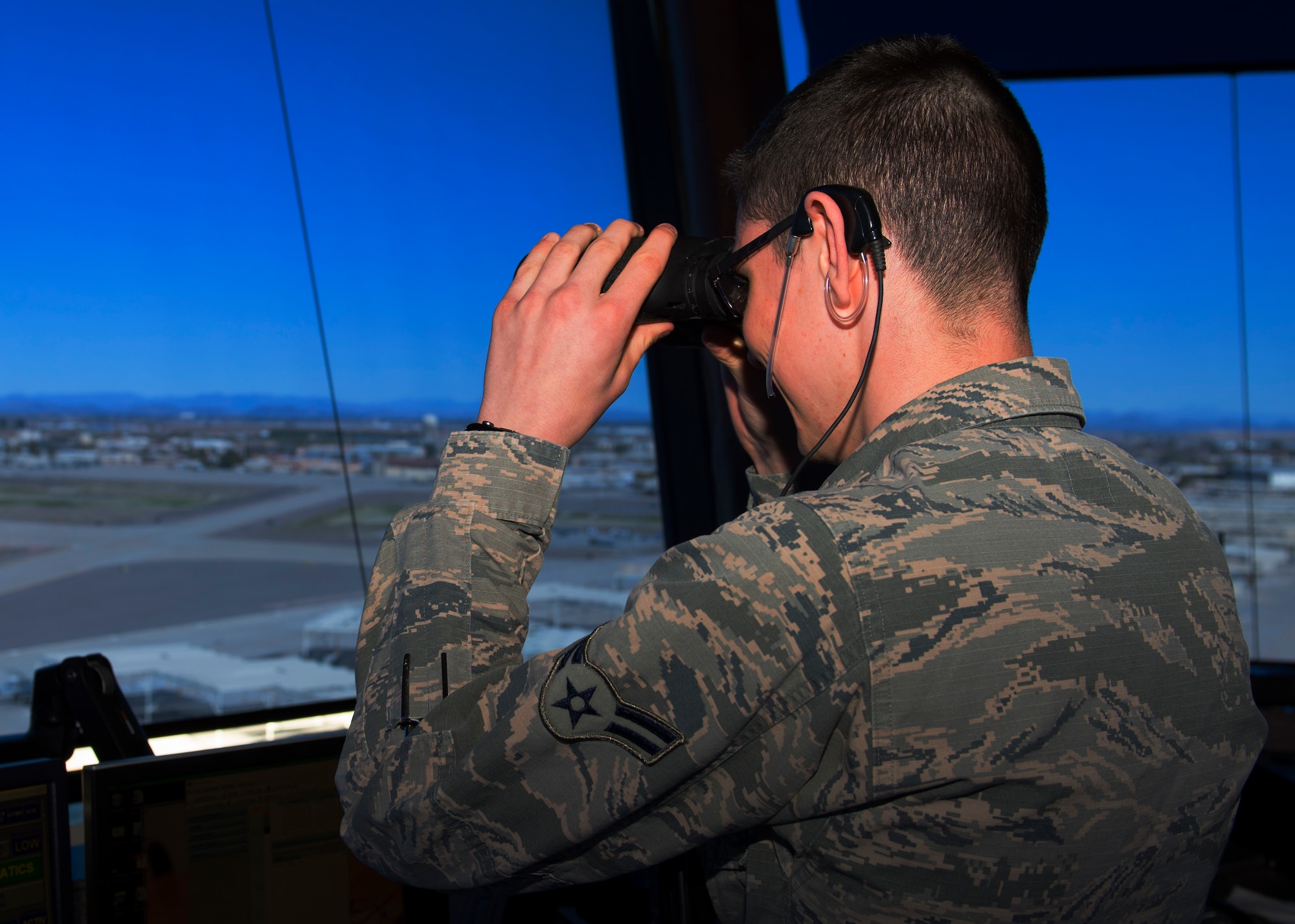Airman 1st Class Morgan Ray, 56th Operations Support Squadron air traffic control apprentice, scans the flight line with binoculars at Luke Air Force Base, Ariz., Feb. 7, 2019.