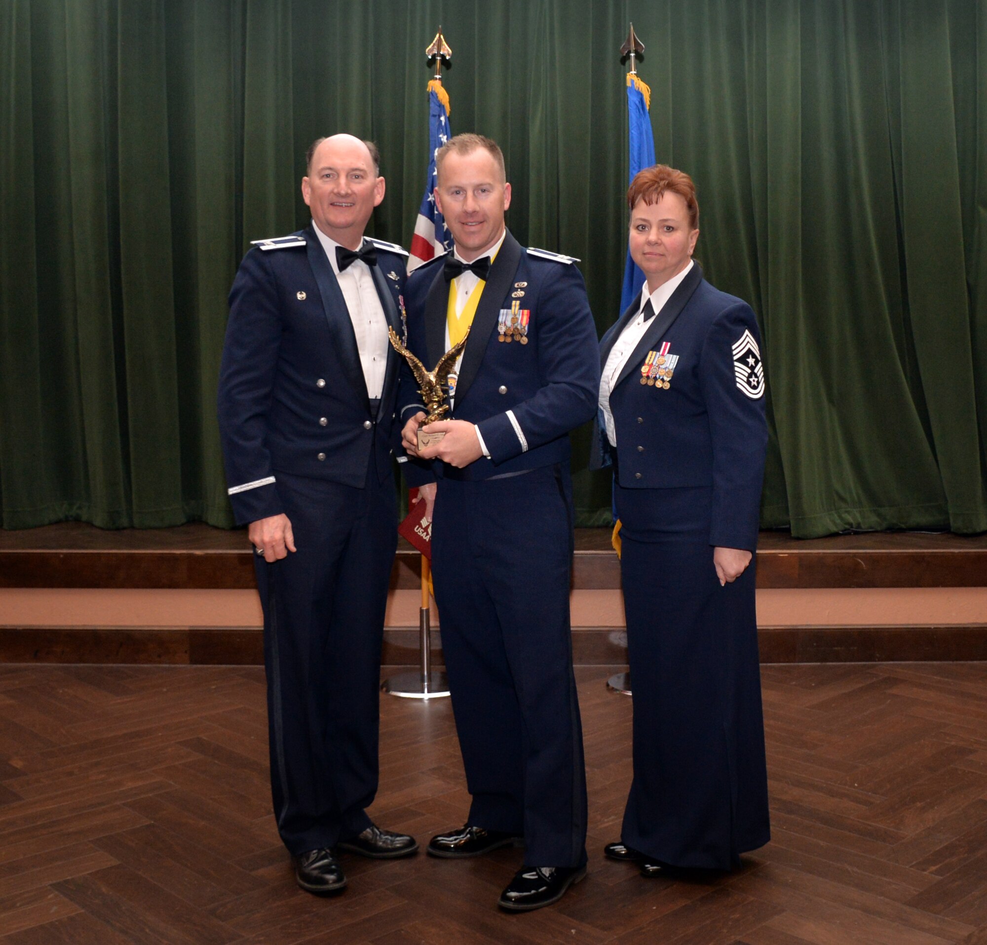 Col. Thomas K. Smith, 433rd Airlift Wing commander, and 433rd AW Command Chief Master Sgt. Shana C. Cullum, award Capt. Chad Marbut, 433rd Civil Engineer Squadron, as the Company Grade Officer of the Year at the 433rd AW annual awards banquet at Joint Base San Antonio-Lackland, Texas Feb. 9, 2019.