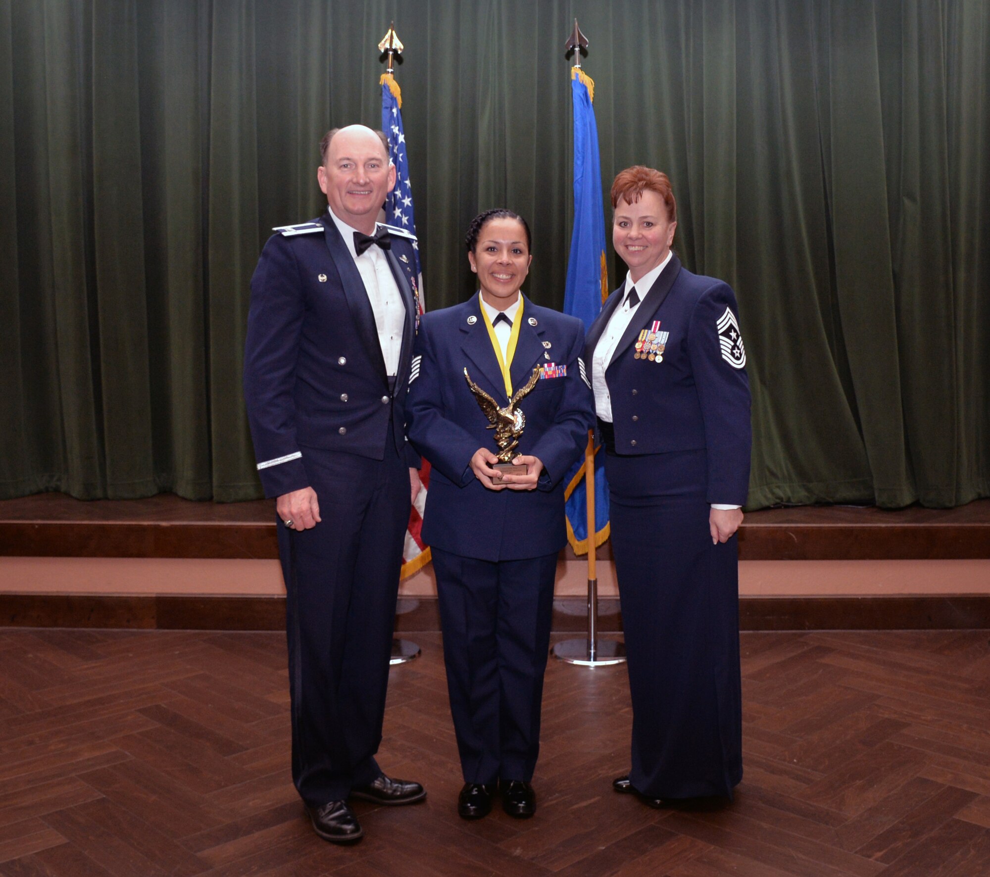 Col. Thomas K. Smith, 433rd Airlift Wing commander, and 433rd AW Command Chief Master Sgt. Shana C. Cullum, award Stephanie Sanchez, 433rd AW Safety Office, as the Civilian Category II of the Year at the 433rd AW annual awards banquet at Joint Base San Antonio-Lackland, Texas Feb. 9, 2019.