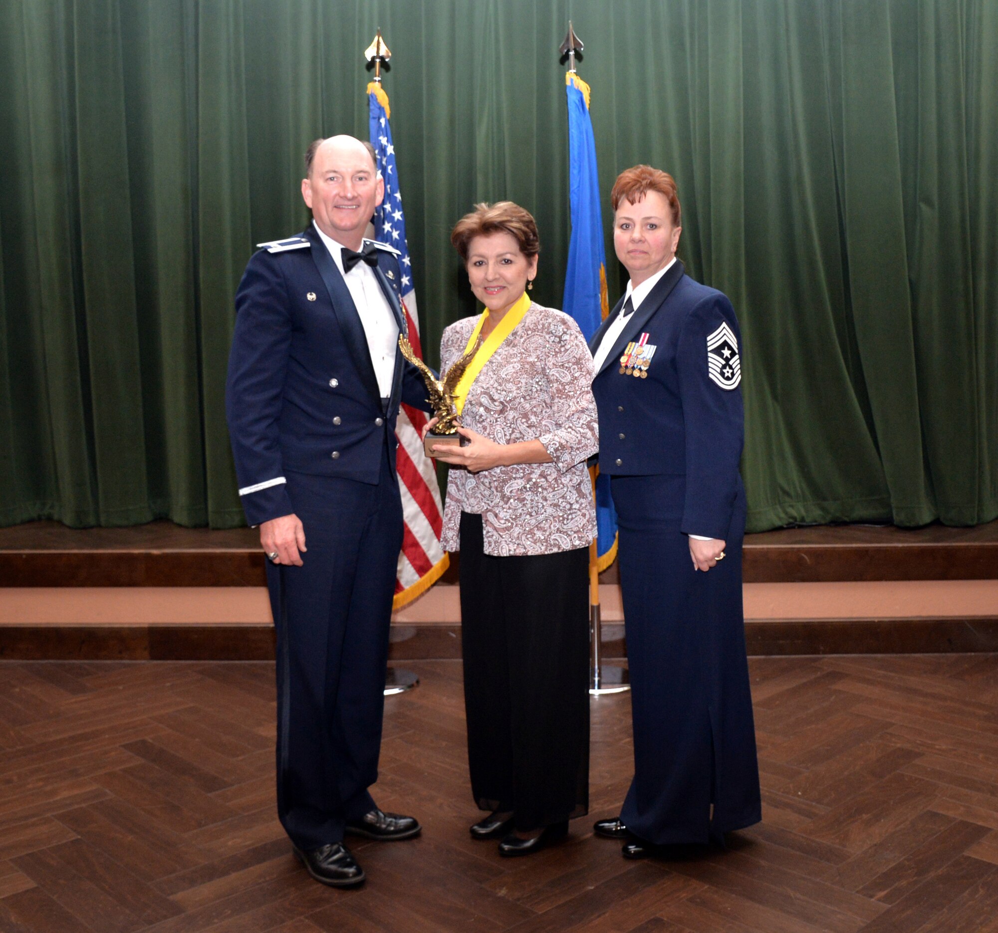 Col. Thomas K. Smith, 433rd Airlift Wing commander, and 433rd AW Command Chief Master Sgt. Shana C. Cullum, award Martha Paller, 433rd AW Financial Services Office, as the Civilian Category III of the Year at the 433rd AW annual awards banquet at Joint Base San Antonio-Lackland, Texas Feb. 9, 2019.