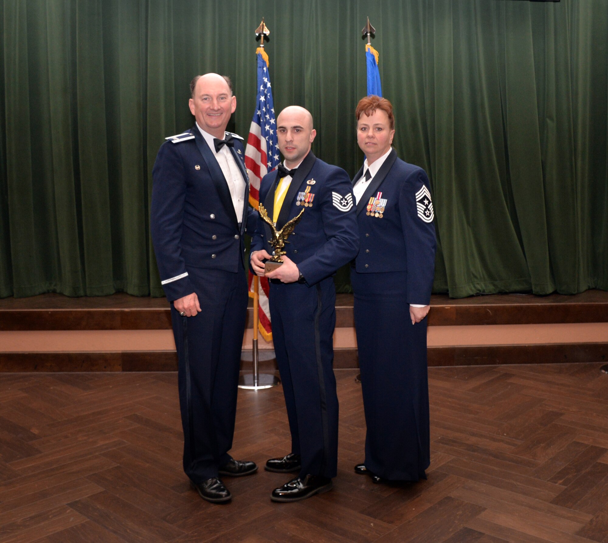 Col. Thomas K. Smith, 433rd Airlift Wing commander, and 433rd AW Command Chief Master Sgt. Shana C. Cullum, award Tech. Sgt. Anthony Martin, 433rd Force Support Squadron, as the Noncommissioned Officer of the Year at the 433rd AW annual awards banquet at Joint Base San Antonio-Lackland, Texas Feb. 9, 2019.