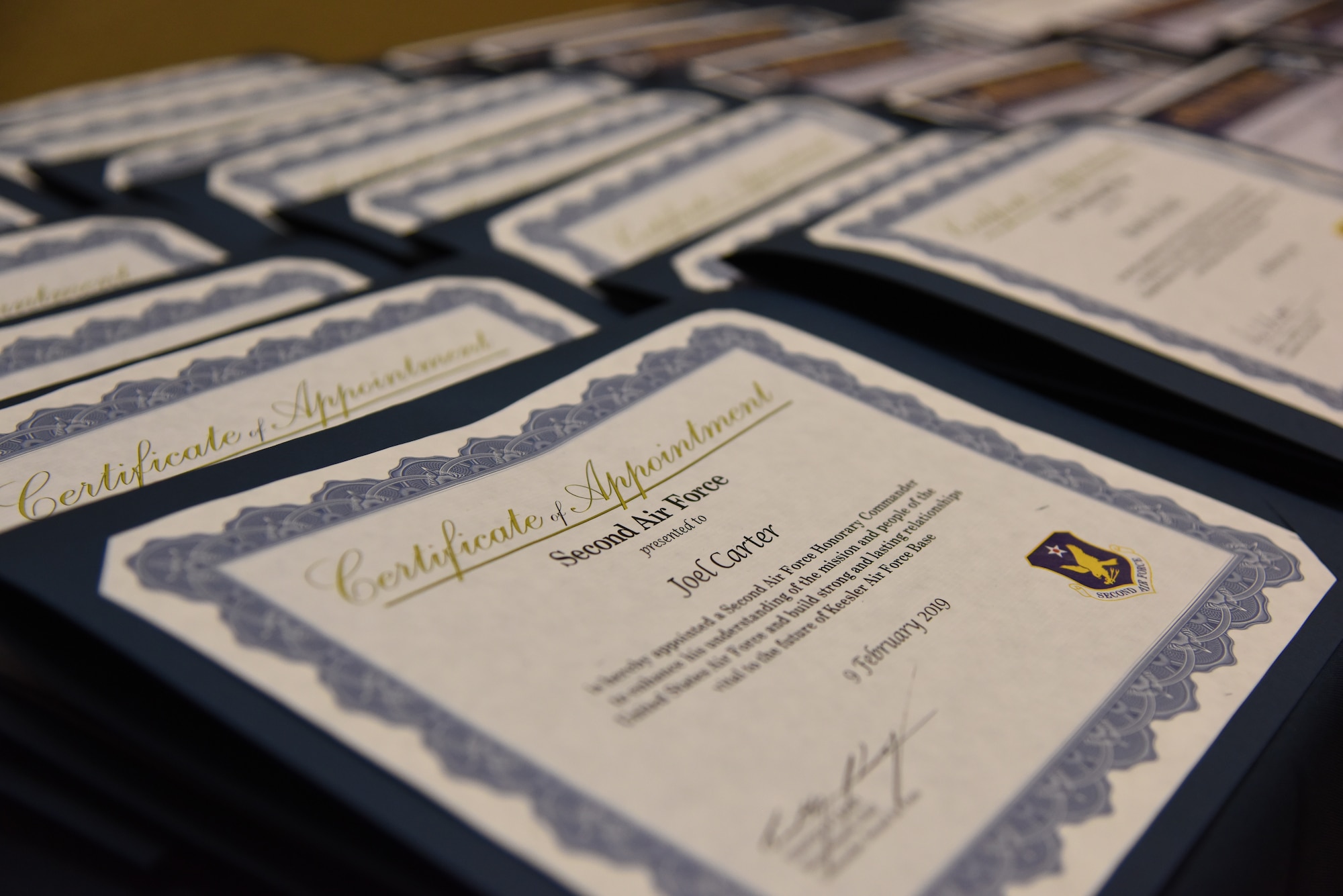 Certificates are displayed during the 2019 Honorary Commander Induction Ceremony inside the Bay Breeze Event Center at Keesler Air Force Base, Mississippi, Feb. 9, 2019. The event recognized the newest members of Keesler's honorary commander program, which is a partnership between military commanders and local civic and business leaders in order to enrich and strengthen the relationship between the base and the community. This was the first time leadership from the 2nd Air Force, 81st Training Wing and 403rd Wing combined to host a single joint induction ceremony. (U.S. Air Force photo by Kemberly Groue)