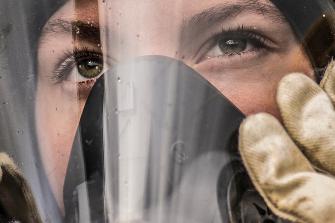 A service member wears a gas mask.