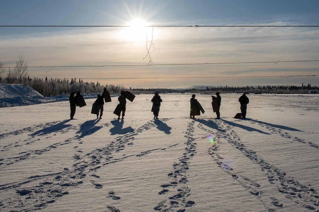 Service members remove targets in the snow.