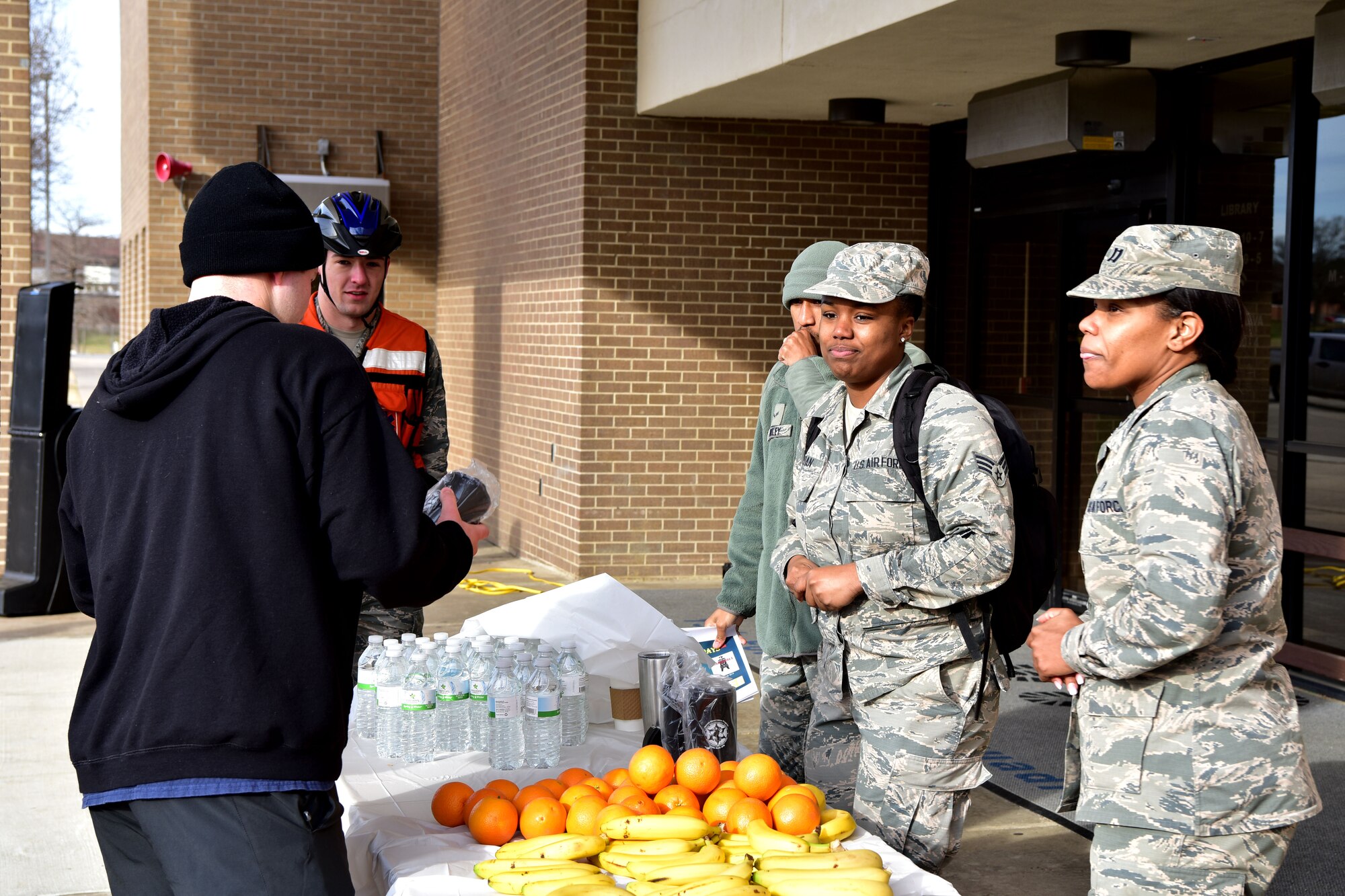 Airmen set up stand with oranges and bananas.