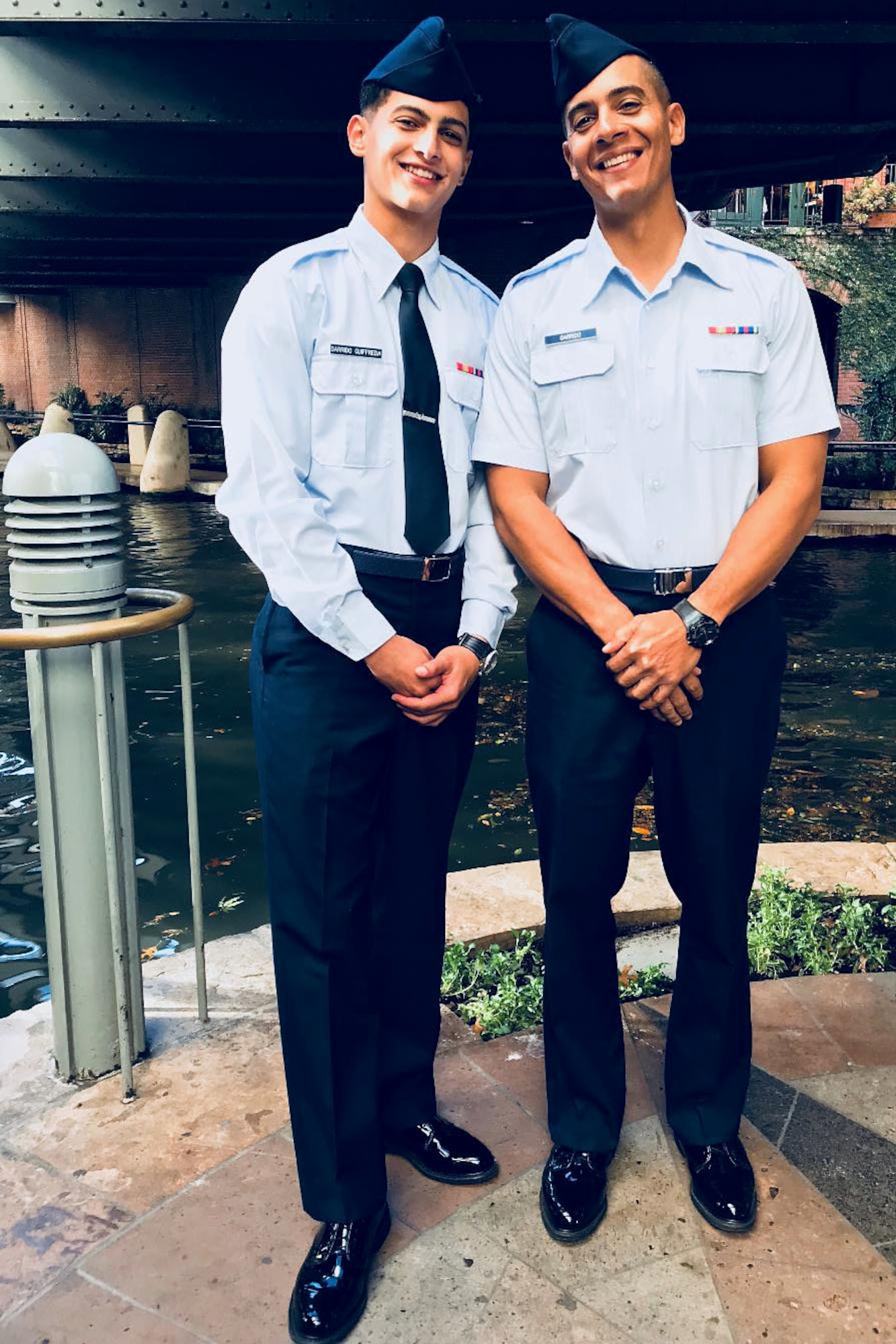 2 Airmen pose for photo after basic military training graduation.