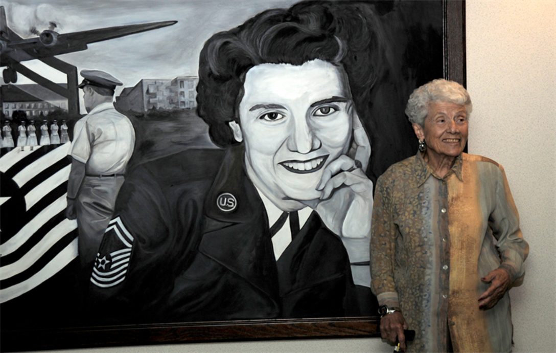 Retired Chief Master Sgt. Grace Peterson stands in front of a painting of herself in front of the Grace Peterson Hall at the U.S. Air Force Expeditionary Center Oct. 18, 2010, at Joint Base McGuire-Dix-Lakehurst, N.J.