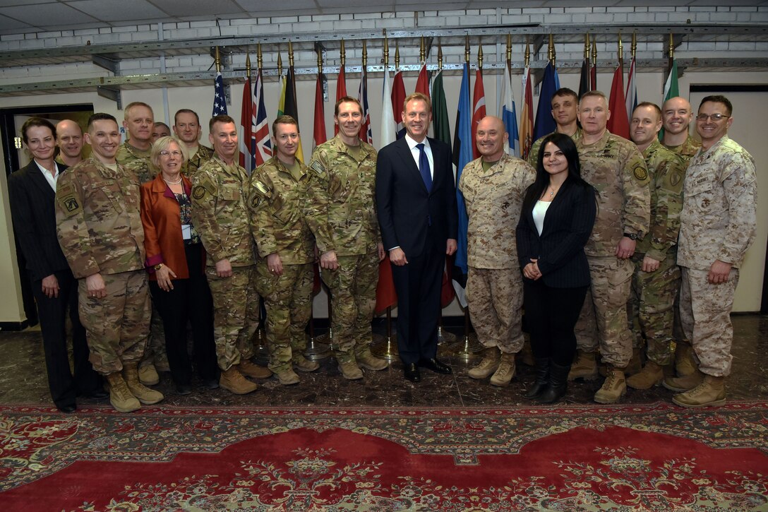 A group of military and civilian leaders pose for a group photo.