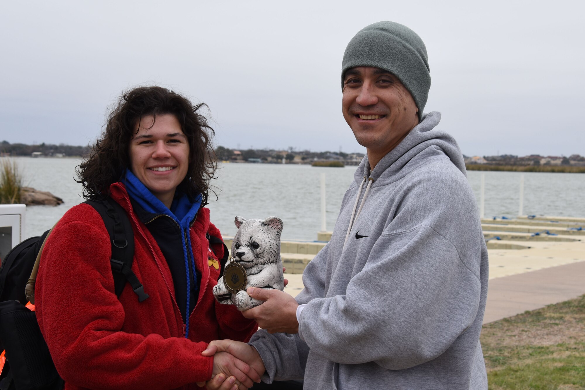 U.S. Air Force Airman Jenica Lock, 312th Training Squadron student, is presented with the top female runner trophy by Col. Ricky Mills, 17th Training Wing commander at the annual Polar Bear Run and Swim on the Goodfellow Recreation Camp at Lake Nasworth Feb. 9, 2019. Lock also took the plunge into the lake after the run and competed in the costume contest during the event. (U.S. Air Force photo by Senior Airman Seraiah Hines/Released)