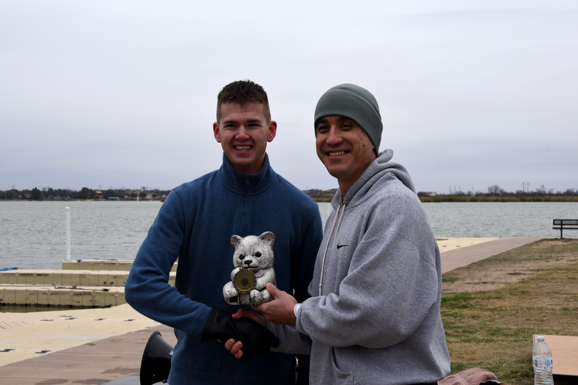 U.S. Air Force Airman 1st Class Andrey Chebotaev, 315th Training Squadron student is presented the top male runner trophy by Col. Ricky Mills, 17th Training Wing commander at the annual Polar Bear Run and Swim on the Goodfellow Recreation camp on Lake Nasworthy Feb. 9, 2019. Mills joined the 30 members of Goodfellow who ran in the 5K at the beginning of the event. (U.S. Air Force photo by Senior Airman Seraiah Hines/Released)