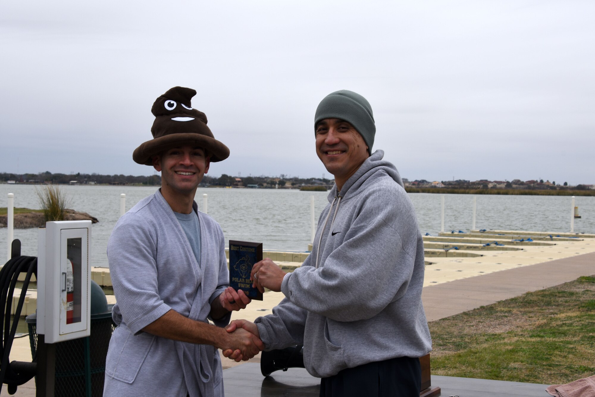 U.S. Air Force 2nd Lt. Christian Nazario, 315th Training Squadron student, receives the best costume award from Col. Ricky Mills, 17th Training Wing commander at the annual Polar Bear Run and Swim on the Goodfellow Recreation Camp at Lake Nasworthy, Feb. 9, 2019. The 17th Force Support Squadron hosts many events at the recreation camp to encourage Airmen and boost morale. (U.S. Air Force photo by Senior Airman Seraiah Hines/Released)