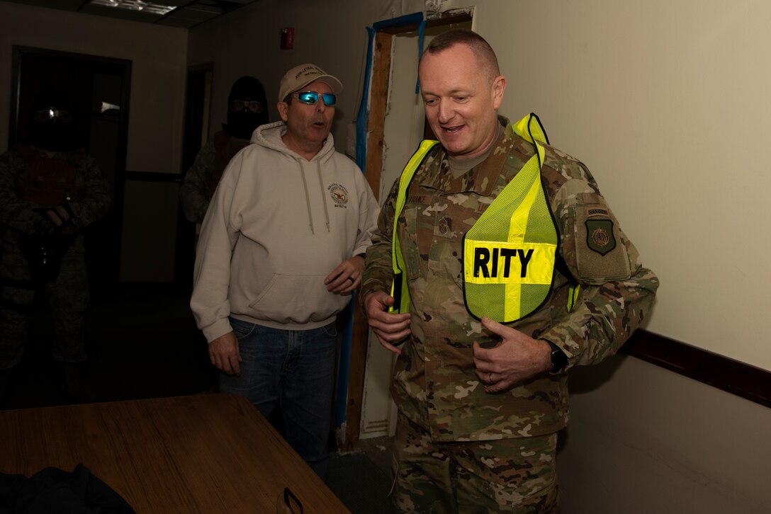 Chief Master Sgt. Jason France, U.S. Transportation Command Senior Enlisted Leader, puts on a safety vest prior to watching a security forces training demonstration Feb. 7, 2019 at Travis Air Force Base, Calif. During his visit, France observed security forces use of force training, toured the installation and met with senior leaders. (U.S. Air Force photo by Tech. Sgt. James Hodgman)