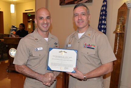 Navy Lt. Anthony Waite, Jr., left, a nurse serving at Naval Health Clinic Charleston, located at Joint Base Charleston, S.C., receives a Navy and Marine Corps Achievement Medal from NHCC Commanding Officer Capt. Dale Barrette during a recent award ceremony at the clinic. Waite was named NHCC’s Junior Officer of the Year.
