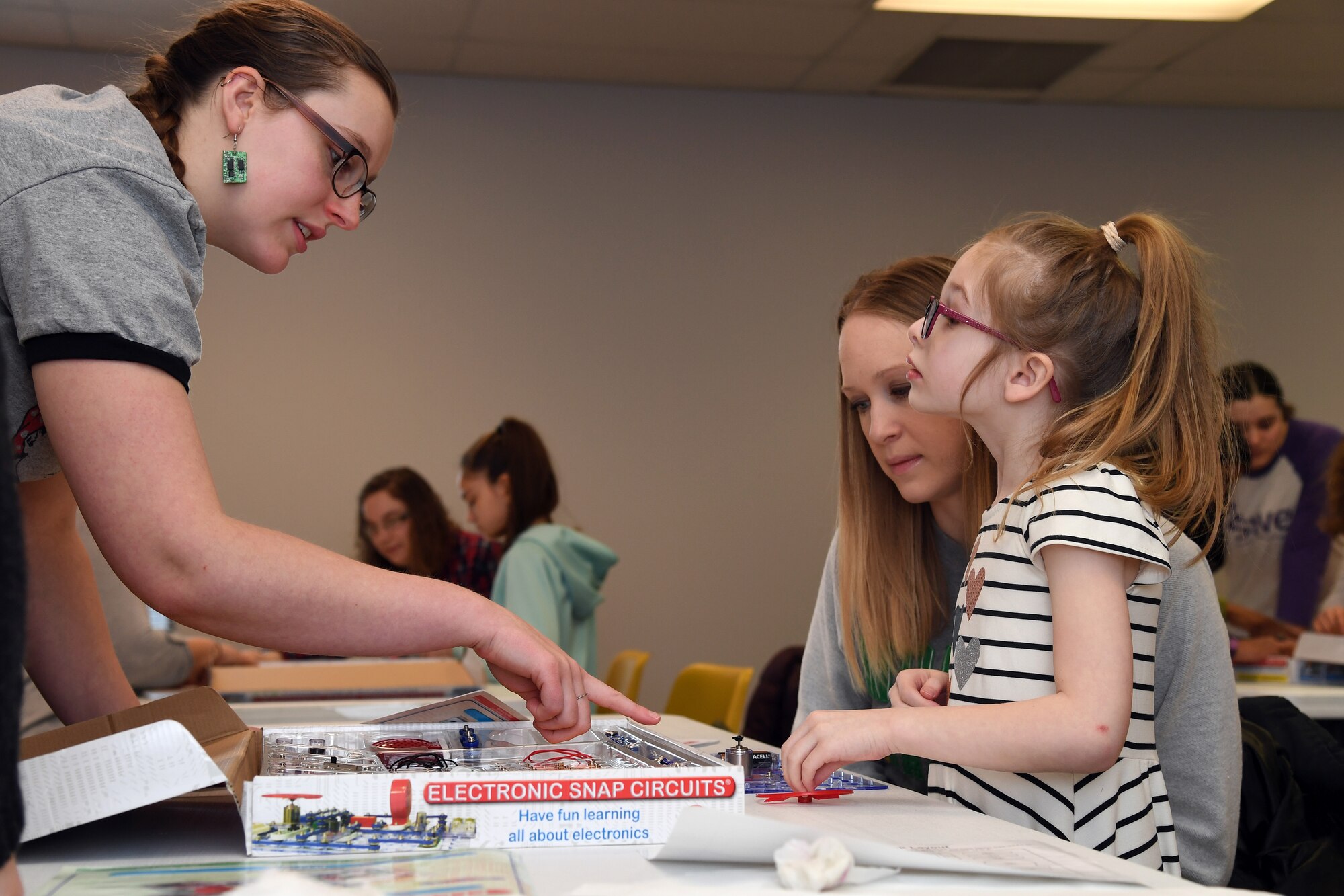 Lucy Praska, 6, listens to the instructions given by a volunteer with the University of North Dakota Society of Women Engineers during an experiment using electronic snap circuits at a science, technology, engineering and mathematics workshop January 26, 2019, in the Grand Forks Public Library. Praska attended the STEM workshop offered for mothers and daughters from Grand Forks Air Force Base, North Dakota, and the local community, and participated in a number of experiments to demonstrate mechanical, electrical and chemical engineering. (U.S. Air Force photo by Senior Airman Elora J. Martinez)