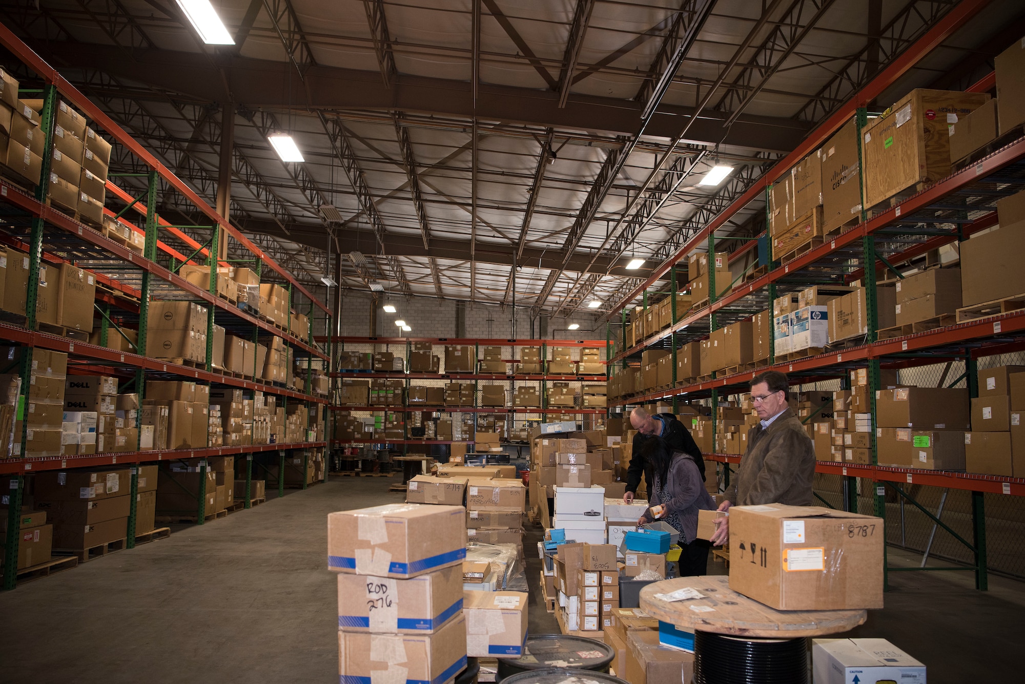Three 30th Contracting Squadron civilians survey items in a warehouse used for storing government furnished property Feb. 12, 2018, on Vandenberg Air Force Base, Calif. The team is responisble for saving $1 billion over the course of seven years.