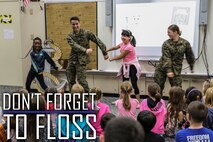Navy Lt. Kristopher Zamora, center left, and Lt. Kathryn Harrington, right, do the “floss” dance with students from Kinser Elementary School Feb. 5, 2019 on Camp Kinser, Okinawa, Japan. Sailors from Naval clinics in Okinawa held a presentation to promote oral health awareness during National Children’s Dental Health Month. Zamora, a general dentist with Branch Dental Clinic Hansen, 3rd Dental Bn., 3rd Marine Logistics Group, is a native of Caldwell, Idaho. Harrington, a general dentist with Branch Dental Clinic Futenma, 3rd Dental Bn., 3rd MLG, is a native of Cleveland, Ohio. (U.S. Marine Corps photo by Armando Elizalde)