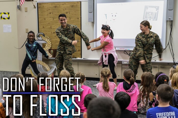 Navy Lt. Kristopher Zamora, center left, and Lt. Kathryn Harrington, right, do the “floss” dance with students from Kinser Elementary School Feb. 5, 2019 on Camp Kinser, Okinawa, Japan. Sailors from Naval clinics in Okinawa held a presentation to promote oral health awareness during National Children’s Dental Health Month. Zamora, a general dentist with Branch Dental Clinic Hansen, 3rd Dental Bn., 3rd Marine Logistics Group, is a native of Caldwell, Idaho. Harrington, a general dentist with Branch Dental Clinic Futenma, 3rd Dental Bn., 3rd MLG, is a native of Cleveland, Ohio. (U.S. Marine Corps photo by Armando Elizalde)