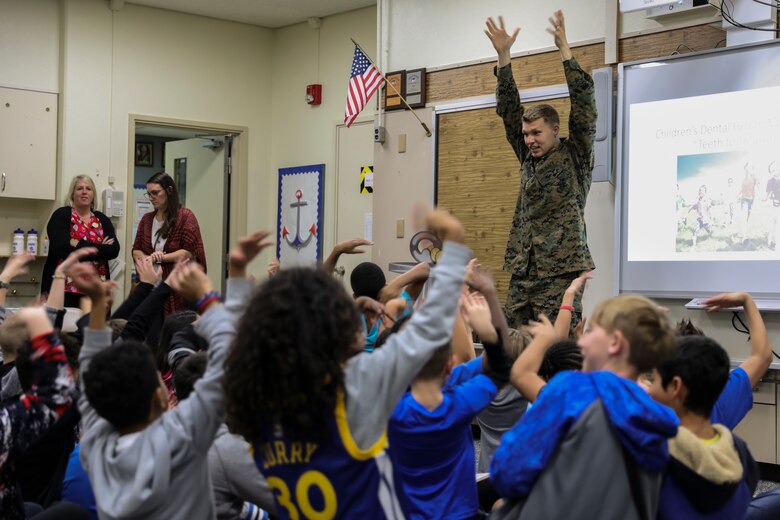 Navy Lt. Michael J. Lawrence, right, gives instructions to students from Kinser Elementary School during a presentation Feb. 5, 2019 on Camp Kinser, Okinawa, Japan. Sailors from Naval clinics in Okinawa held a presentation to promote oral health awareness during National Children’s Dental Health Month. Lawrence, a general dentist with Branch Dental Clinic Evans, 3rd Dental Battalion, 3rd Marine Logistics Group, is a native of Troutdale, Oregon. (U.S. Marine Corps photo by Lance Cpl. Armando Elizalde)