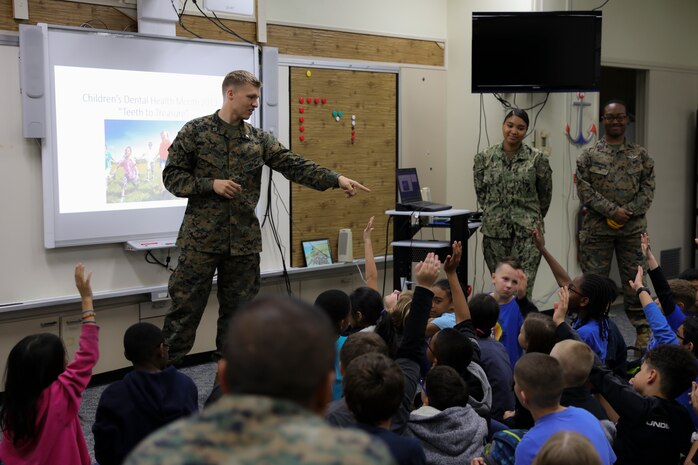 Navy Lt. Michael J. Lawrence, left, gives instructions to students from Kinser Elementary School during a presentation Feb. 5, 2019 on Camp Kinser, Okinawa, Japan. Sailors from Naval clinics in Okinawa held a presentation to promote oral health awareness during National Children’s Dental Health Month. Lawrence, a general dentist with Branch Dental Clinic Evans, 3rd Dental Battalion, 3rd Marine Logistics Group, is a native of Troutdale, Oregon. (U.S. Marine Corps photo by Lance Cpl. Armando Elizalde)